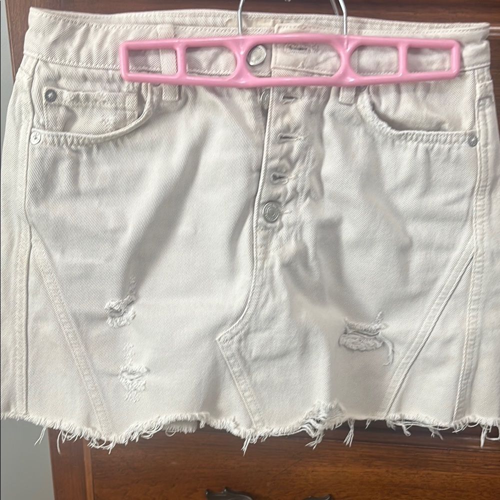 Distressed Cream Denim Skirt with buttons in front of the Jean skirt